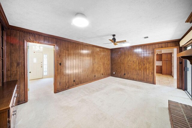 5004 22nd Ave, Phenix City, AL 36867 - unfurnished room with wooden walls, light colored carpet, ornamental molding, a ceiling fan, and a textured ceiling