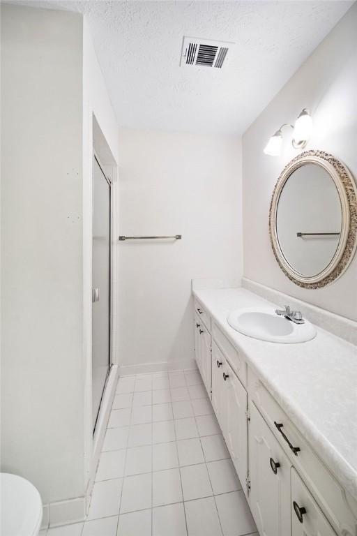 5004 22nd Ave, Phenix City, AL 36867 - full bathroom with vanity, a shower stall, and a textured ceiling