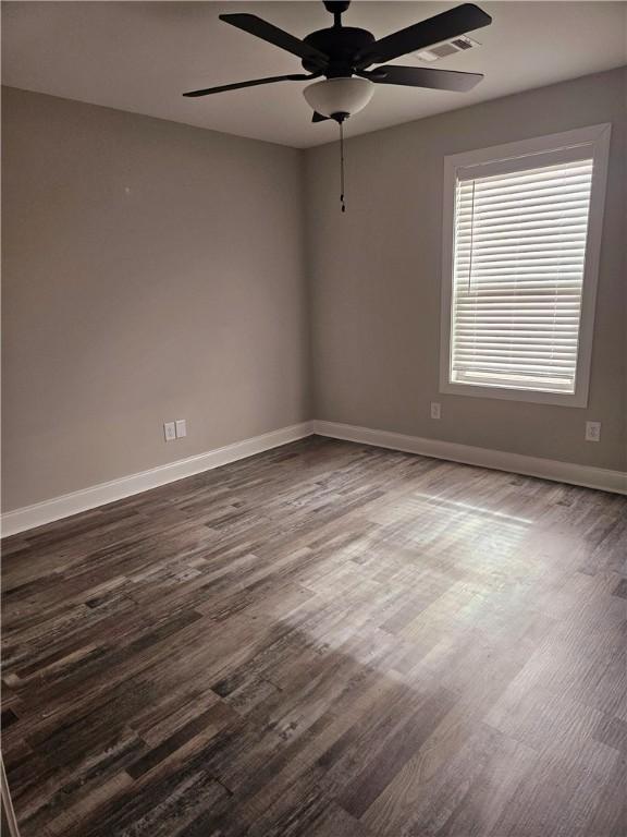 unfurnished room with ceiling fan and dark hardwood / wood-style floors