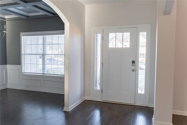 entrance foyer featuring beamed ceiling, ornamental molding, dark wood-type flooring, and coffered ceiling