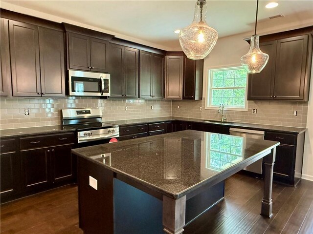42 Lee Road 2234, Smiths Station, AL 36877 - kitchen with appliances with stainless steel finishes, dark brown cabinetry, dark stone countertops, dark wood finished floors, and recessed lighting