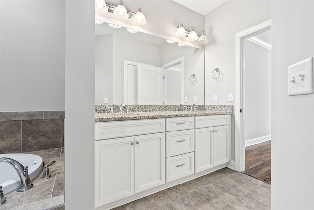 bathroom featuring double vanity, a sink, and a tub