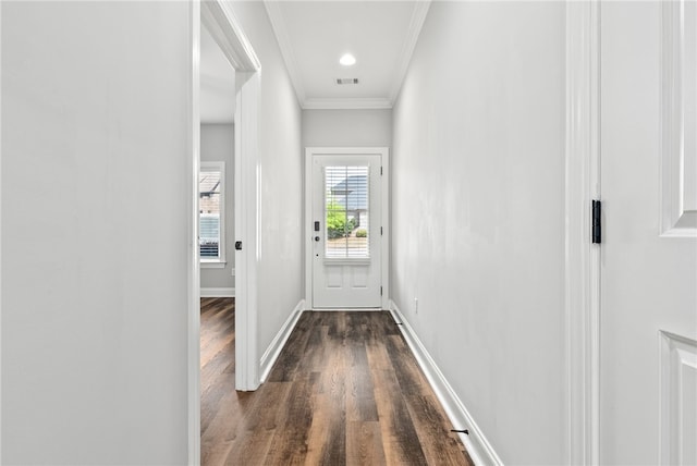 doorway with baseboards, visible vents, crown molding, and dark wood-type flooring