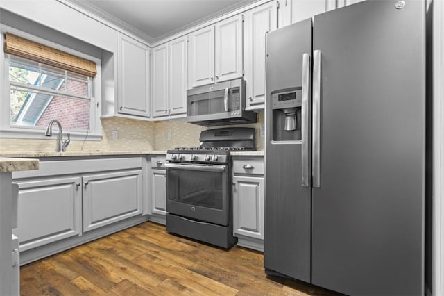 kitchen featuring dark wood-type flooring, white cabinetry, light countertops, appliances with stainless steel finishes, and tasteful backsplash