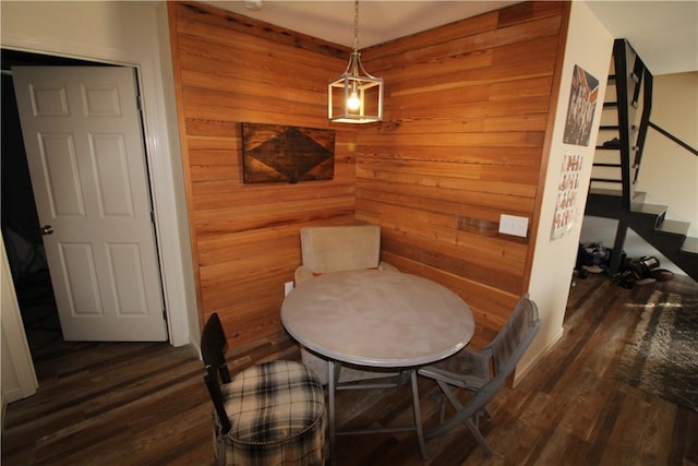 dining area featuring dark hardwood / wood-style floors and wood walls