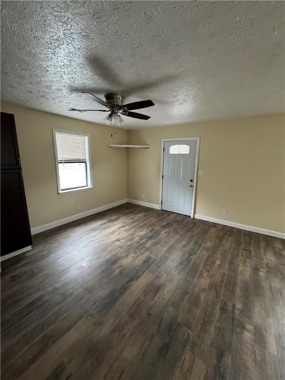 interior space featuring a textured ceiling, ceiling fan, and dark hardwood / wood-style floors