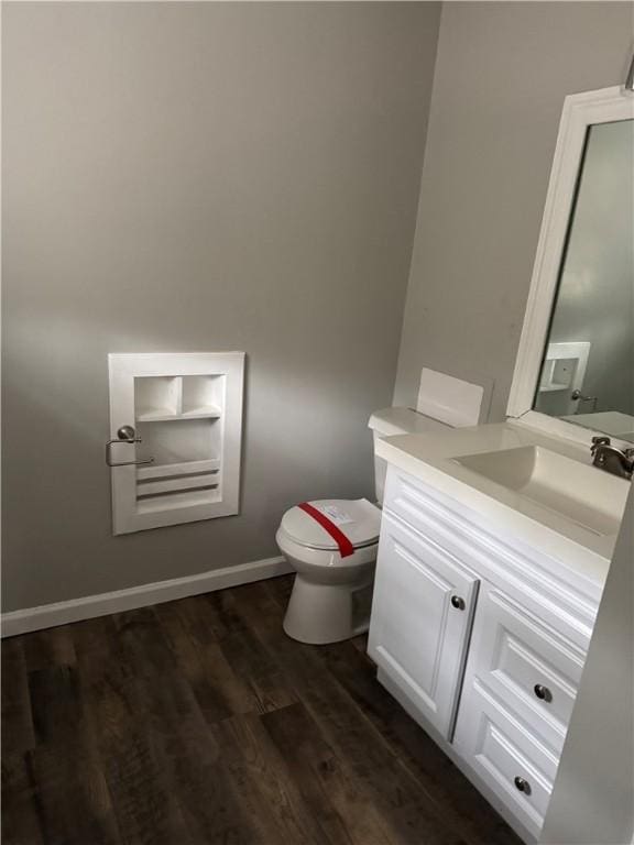 bathroom with hardwood / wood-style floors, vanity, and toilet