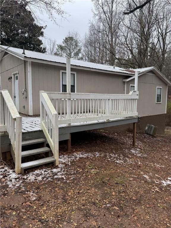 rear view of property featuring a wooden deck