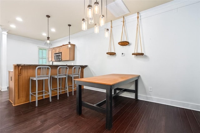 650 Dekalb St Unit 4302, Auburn, AL 38630 - bar with stainless steel microwave, dark wood-style floors, hanging light fixtures, recessed lighting, and ornamental molding
