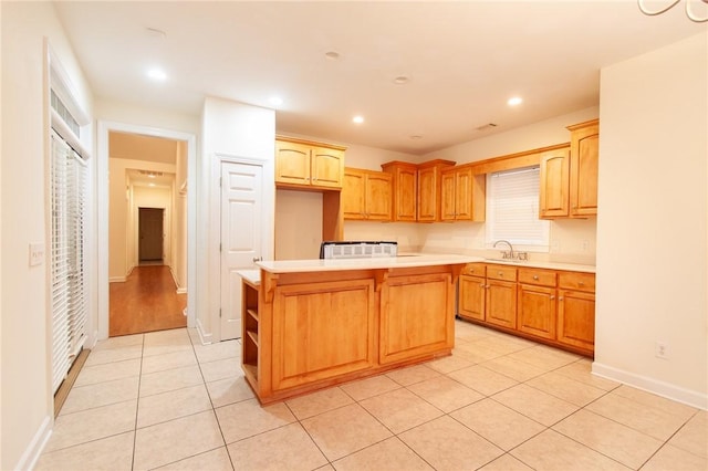 kitchen featuring a center island, light tile patterned floors, and sink