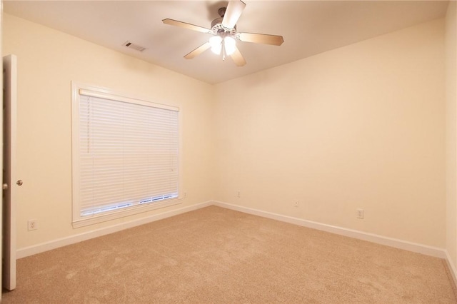 spare room with ceiling fan and light colored carpet