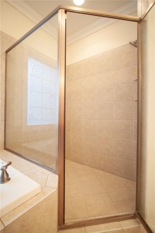 bathroom with a tile shower and ornamental molding