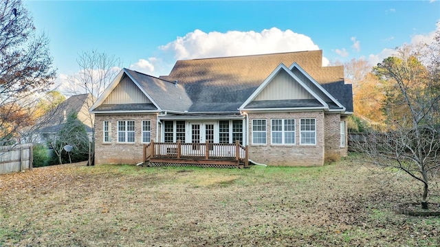 rear view of house with a lawn and a wooden deck