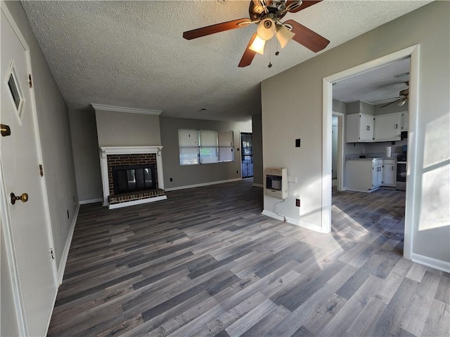 unfurnished living room featuring a fireplace, hardwood / wood-style floors, a textured ceiling, and heating unit