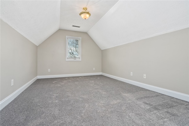 bonus room with vaulted ceiling, carpet, and a textured ceiling