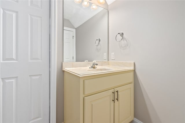 bathroom with lofted ceiling and vanity