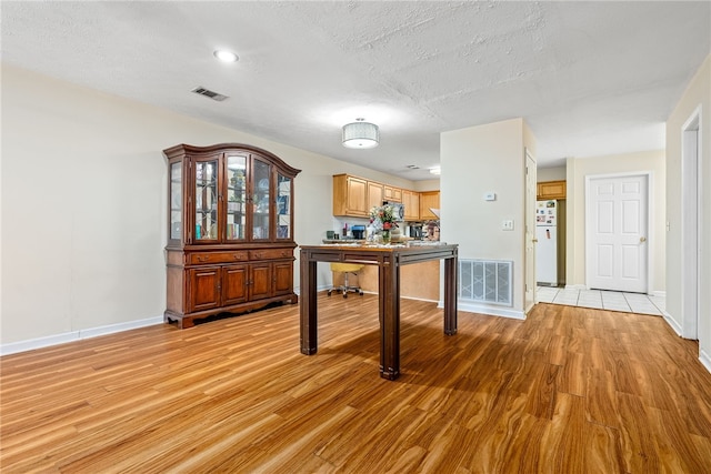 interior space featuring light hardwood / wood-style floors and a textured ceiling