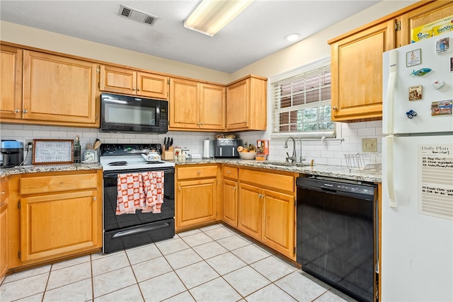 kitchen with light stone countertops, backsplash, sink, black appliances, and light tile patterned floors