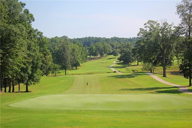 view of home's community featuring view of golf course and a yard