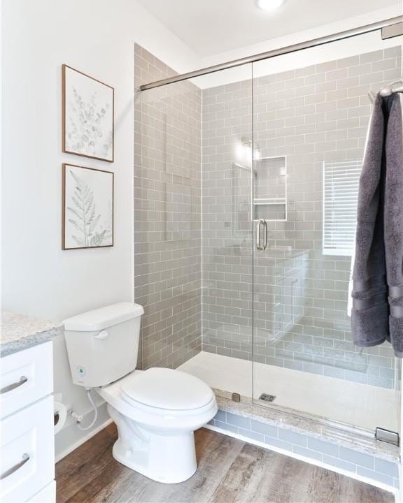 1066 Hunters Way, Opelika, AL 36801 - bathroom featuring vanity, a shower stall, and wood finished floors