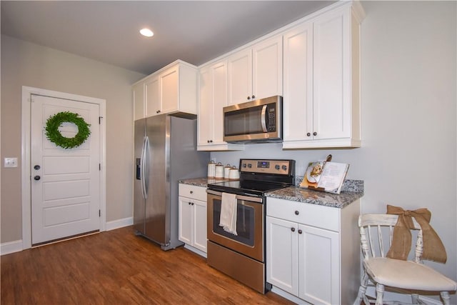 2046 Stephanie Ct, Auburn, AL 36830 - kitchen featuring stainless steel appliances, white cabinets, dark wood-style floors, dark stone counters, and recessed lighting