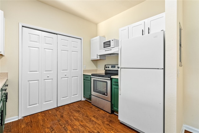 kitchen with under cabinet range hood, white appliances, dark wood-type flooring, green cabinets, and light countertops