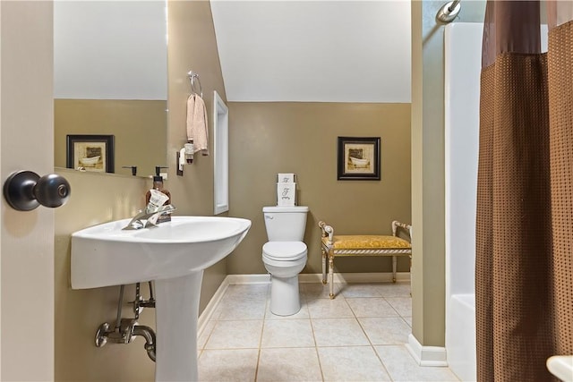 bathroom with tile patterned flooring, vaulted ceiling, and toilet