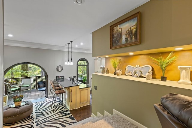 interior space featuring decorative light fixtures, dark hardwood / wood-style floors, plenty of natural light, and crown molding