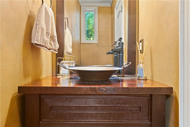 bathroom featuring vanity and ornamental molding