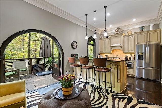 kitchen with decorative backsplash, stainless steel fridge, pendant lighting, a center island, and a breakfast bar area