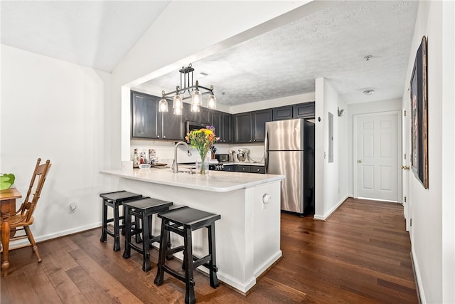 1114 S College St Unit 302, Auburn, AL 36830 - kitchen featuring dark wood finished floors, stainless steel appliances, baseboards, a peninsula, and a breakfast bar area