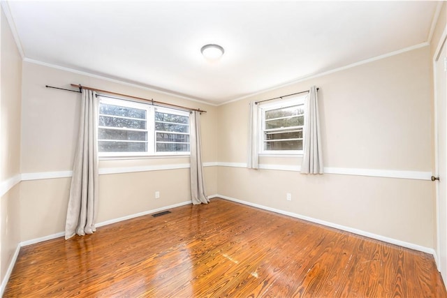 empty room featuring crown molding and hardwood / wood-style floors