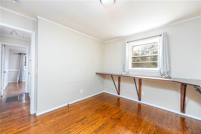 spare room featuring ornamental molding, wood-type flooring, and built in desk