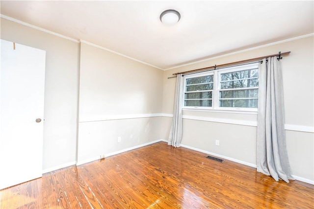 empty room with hardwood / wood-style flooring and ornamental molding