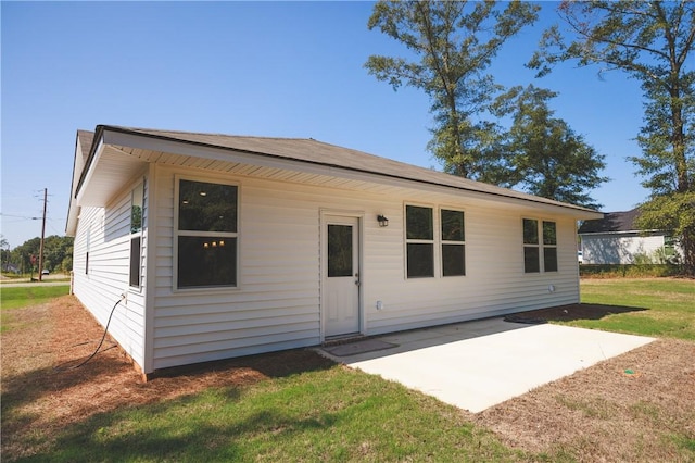 back of house with a lawn and a patio