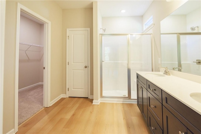 bathroom featuring hardwood / wood-style flooring, vanity, and walk in shower