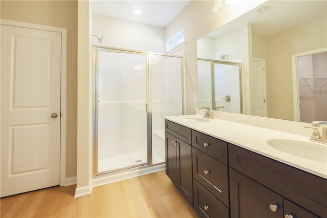 bathroom with a shower with door, vanity, and hardwood / wood-style flooring