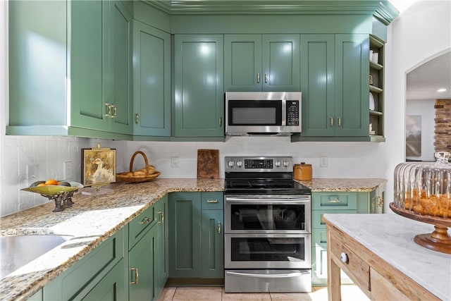 kitchen with backsplash, stainless steel appliances, open shelves, and green cabinets