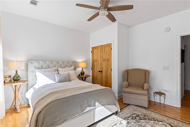 bedroom featuring a ceiling fan, a closet, baseboards, visible vents, and light wood-type flooring