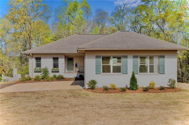 single story home featuring a shingled roof and a front yard