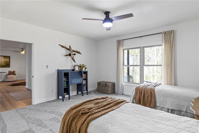 carpeted bedroom featuring baseboards and a ceiling fan
