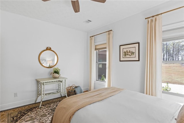bedroom with baseboards, a ceiling fan, and visible vents