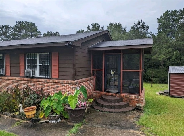 2102 Susie Cir, Tuskegee, AL 36083 - view of front facade with brick siding, a sunroom, and a front lawn