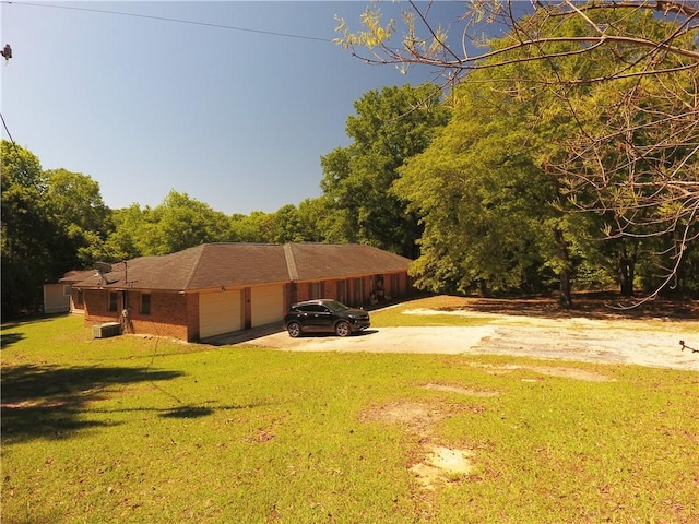 26 Arrowhead Rd, Phenix City, AL 36869 - view of side of home with an attached garage, concrete driveway, a yard, and brick siding