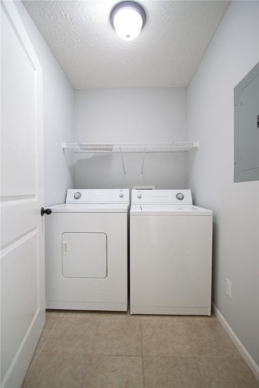 washroom featuring baseboards, washing machine and dryer, electric panel, laundry area, and a textured ceiling