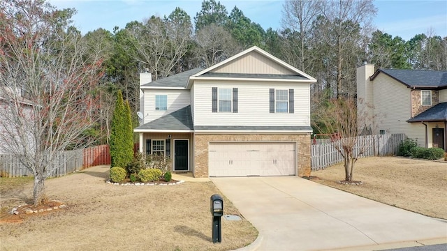 traditional home featuring concrete driveway, a garage, fence, and brick siding