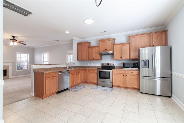 kitchen featuring visible vents, under cabinet range hood, a sink, appliances with stainless steel finishes, and crown molding