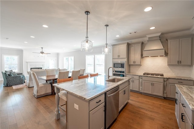1534 Everly Dr, Opelika, AL 36801 - kitchen featuring premium range hood, stainless steel appliances, gray cabinetry, a kitchen bar, and backsplash