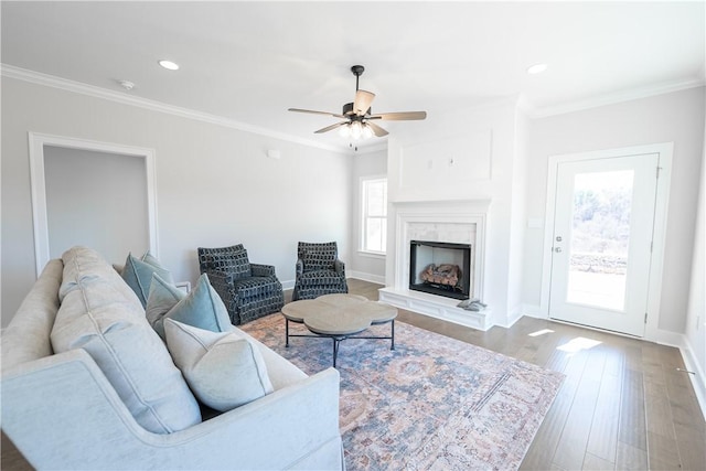 living room with crown molding, light hardwood / wood-style flooring, and ceiling fan