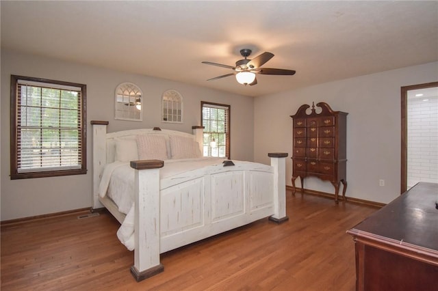 bedroom featuring multiple windows, ceiling fan, and wood-type flooring